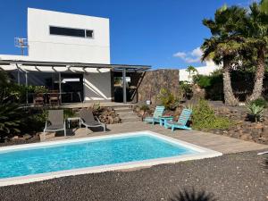 una piscina frente a una casa en Majanicho Rock - villa with heated pool, en Lajares