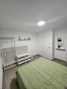 a bedroom with a green bed and a green blanket at Piso de diseño Elche in Elche