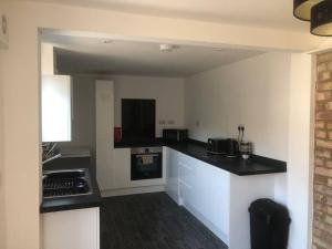 a kitchen with black and white counters and appliances at Bellingham house 3 bedroom home in Brumby
