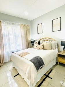 Trendy, Comfortable 1 bedroom Apartments in Mthatha في امتاتا: غرفة نوم بسرير ابيض كبير ونافذة