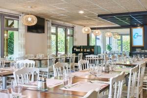 une salle à manger avec des tables, des chaises et des lustres dans l'établissement The Originals City Hôtel La Verrière-Yvelines, à La Verrière