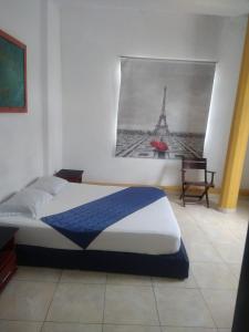 a bedroom with a bed and a picture of the eiffel tower at Hotel Central Park in El Espinal