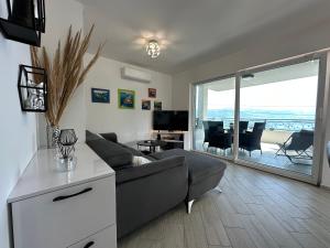 a living room with a couch and a table and a balcony at Villa La Bomboniera in Slatine