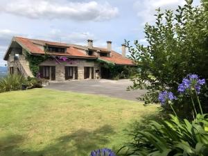 an old house with a yard with purple flowers at Casa do Alto (ground floor apartment) in Adaúfe