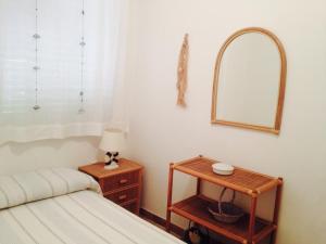 a bedroom with a bed and a table with a mirror at Villagiò in Siracusa