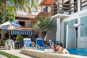 Eine Frau, die im Swimmingpool eines Hotels liegt. in der Unterkunft Hotel Pousada Da Sereia in Maceió