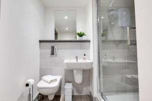 La salle de bains est pourvue d'un lavabo, de toilettes et d'une douche. dans l'établissement Modern & Centrally Located Apartment, à Liverpool