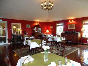 een restaurant met tafels en stoelen in een kamer met rode muren bij Rhins of Galloway in Cairnryan