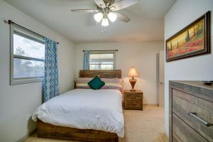 a bedroom with a bed with a ceiling fan and a window at Louisiana Abode - Balcony, Pool Table and Lake Views in Lake Charles