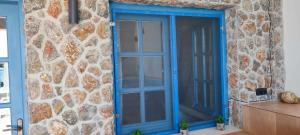 a blue door on the side of a stone wall at FILINA's luxury house in Maltezana +44 photos