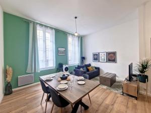 - un salon avec une table et un canapé dans l'établissement Nimes: Appartement l'Auguste Centre-Ville., à Nîmes