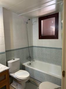 La salle de bains est pourvue de toilettes et d'une baignoire. dans l'établissement Ático junto al Mar,Acceso directo a la playa,Jardines de Nuevo Vera,WIFI, à Vera
