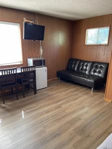 a living room with a black leather couch and a table at Mountain View Cabins in Wrightwood