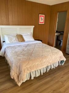 a large bed in a bedroom with wooden walls at Mountain View Cabins in Wrightwood