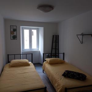 2 Betten in einem Zimmer mit Fenster in der Unterkunft Casa Labirinto vakantie-appartementen in Barna
