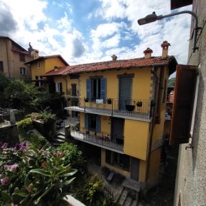 ein gelbes Haus mit einem Balkon und Blumen in der Unterkunft Casa Labirinto vakantie-appartementen in Barna