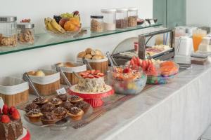 um buffet com queques e outras sobremesas num balcão em Hotel Pousada Da Sereia em Maceió