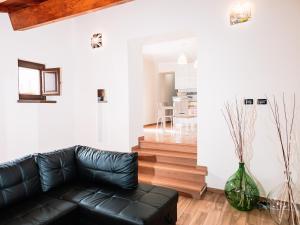 ein Wohnzimmer mit einem schwarzen Ledersofa und einem Esszimmer in der Unterkunft A Casa Mia B&B in Barisciano
