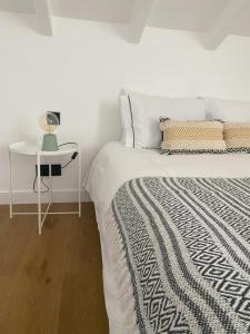 グランドラにあるGrândola Suites - Suite Loftのベッドルーム1室(ベッド1台、ランプ付きテーブル付)