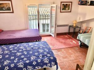 a bedroom with two beds and a door to a balcony at Magalas Top Apartment in Magalas