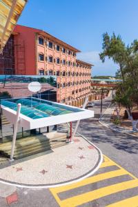 a building with a swimming pool next to a street at Porto d'Aldeia Hotel by Castelo Itaipava in Fortaleza