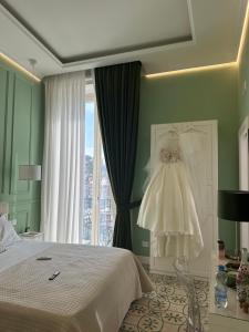 - une chambre avec un lit et une robe suspendue à une fenêtre dans l'établissement Domus Capodimonte, à Naples