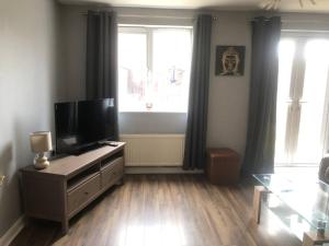 a living room with a flat screen tv on a dresser at Greyfriar House in Brumby