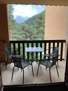 een tafel en 4 stoelen op een balkon met uitzicht bij Lilaubaoli in Valdeblore