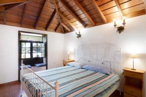 a bedroom with a white bed and a wooden ceiling at El Morro in Tijarafe