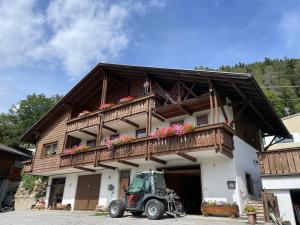 een tractor geparkeerd voor een gebouw met een balkon bij Stroblhof in Vipiteno