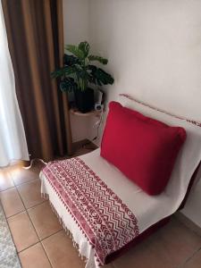 a red pillow sitting on a bed in a room at AT HOME studio rénové près de la plage in Sainte-Anne +52 photos