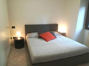 Un dormitorio con una cama con una almohada roja. en Appartamento Poli con giardino, en Castiglione dei Pepoli