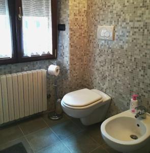 y baño con aseo y lavamanos. en Appartamento Poli con giardino, en Castiglione dei Pepoli