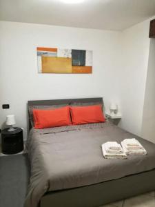 1 dormitorio con 1 cama con 2 almohadas rojas en Appartamento Poli con giardino, en Castiglione dei Pepoli