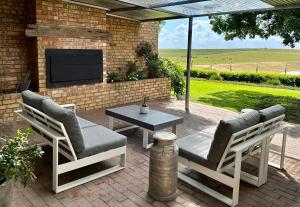 a patio with two chairs and a table and a tv at Primo farm in Windmeul