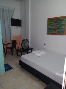 a bedroom with a bed and a table and chairs at Hotel Central Park in El Espinal