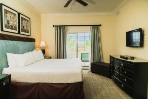 キシミーにあるReunion Resort & Golf Clubのベッドとテレビが備わるホテルルームです。