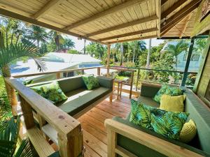 porche con sofá verde y terraza de madera en Cabarete Boutique Kite Hotel for up to 15 people en Cabarete