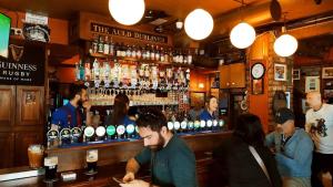 un grupo de personas sentadas en un bar en The Auld Dubliner, en Dublín