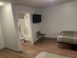 a bedroom with a bed and a bathroom with a toilet at Motel 6-Richmond, VA - I-64 West in Richmond