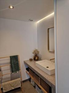 y baño con lavabo blanco y espejo. en Cais da Estação da Luz, en Luz de Tavira