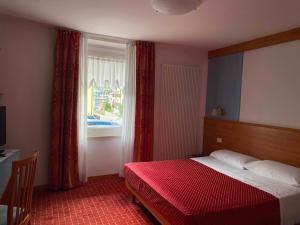 um quarto de hotel com uma cama e uma janela em Hotel Londra Slow Living Molveno em Molveno
