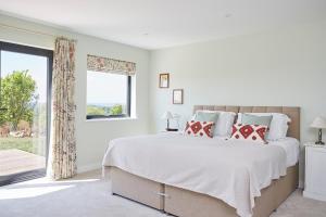 a white bedroom with a large bed and a window at The Wendy House in Yarmouth +23 photos