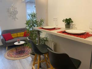 a living room with a counter with chairs and a table at Charmant appartement proche du centre ville in Caen +7 photos