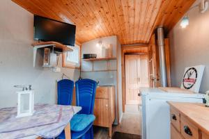 a kitchen with a table and blue chairs in a trailer at Tinyhouse auf dem Sonnenhang in Osterode