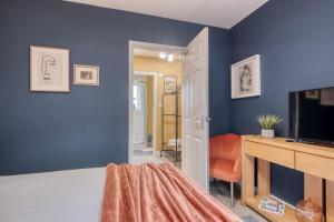 sala de estar con paredes azules y TV en Malvern Hills Rosa Rambler Suite, en Great Malvern