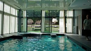 a large swimming pool in a building with glass doors at L'expérience Chartraine in Chartres