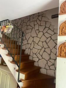 a staircase in a room with a stone wall at Casetta Gianni&Bea in Rocca di Cambio