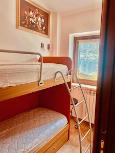 een kamer met 2 stapelbedden en een raam bij Casetta Gianni&Bea in Rocca di Cambio