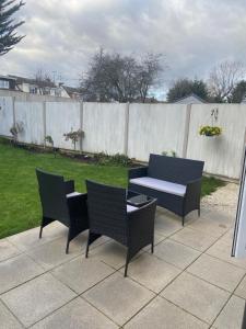 um pátio com 2 cadeiras, uma mesa e uma cerca em Villa Belle Three bedroom Basildon em Basildon